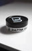 Jar of sculpting clay with a black lid on a white surface